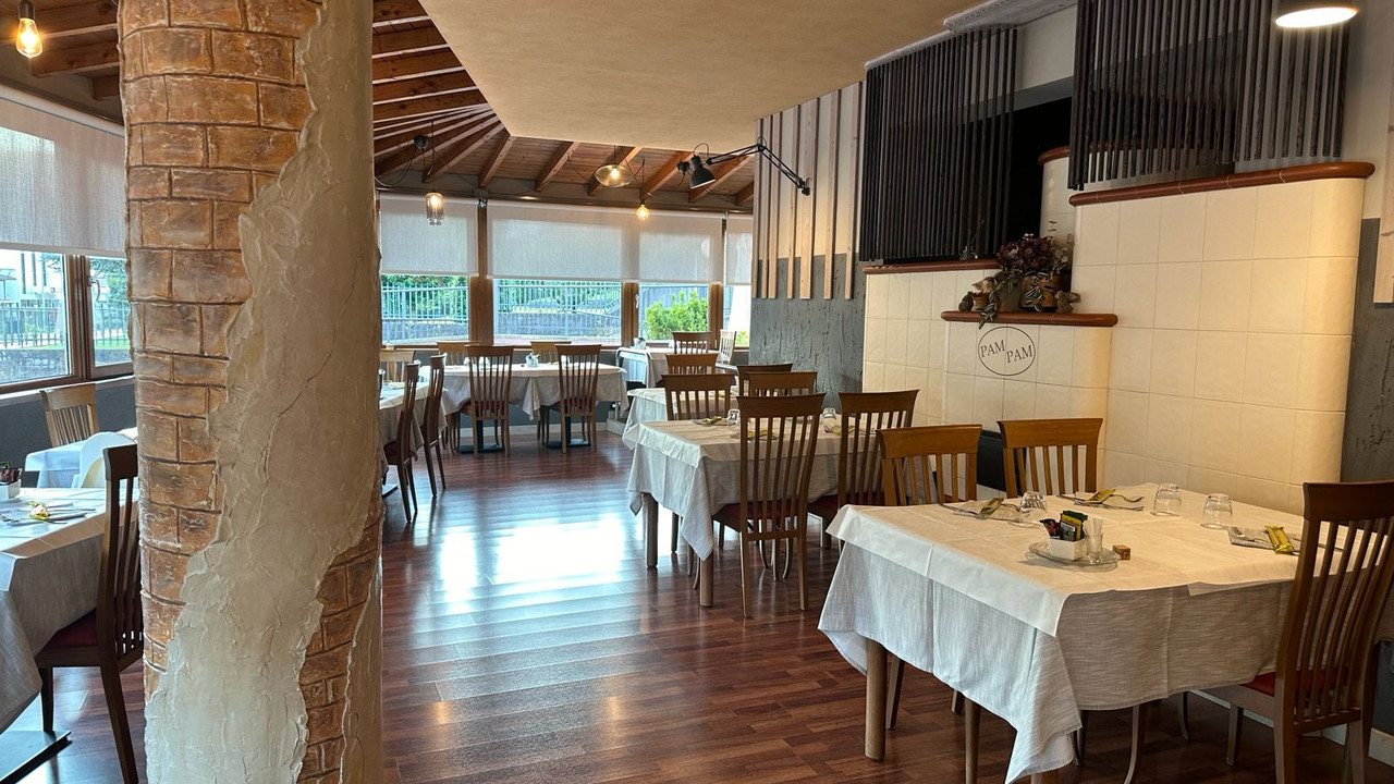 Sala principale del Pam Pam con tavoli apparecchiati e colonna in pietra